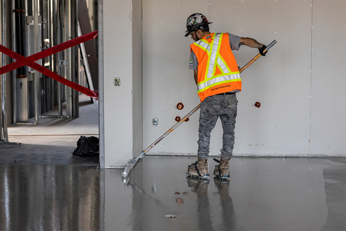 man in high visibility vest working on concrete floor side view