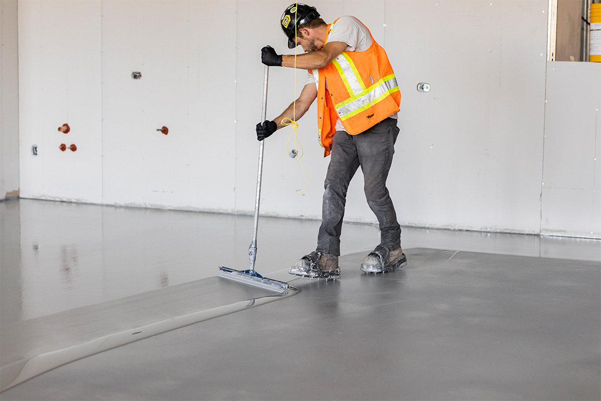 man in high visibility vest working on concrete floor another side shot